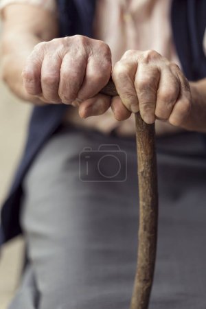 Téléchargez les photos : Détail des mains d'une femme âgée tenant une canne. Concentration sélective - en image libre de droit