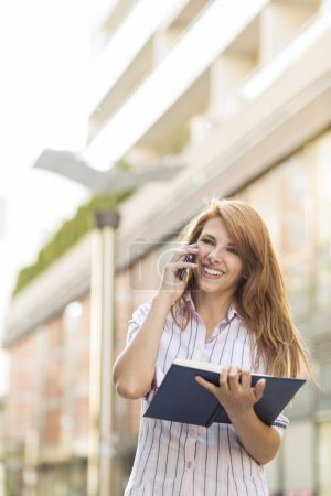 Téléchargez les photos : Femme d'affaires moderne ayant une conversation téléphonique avec un collègue - en image libre de droit