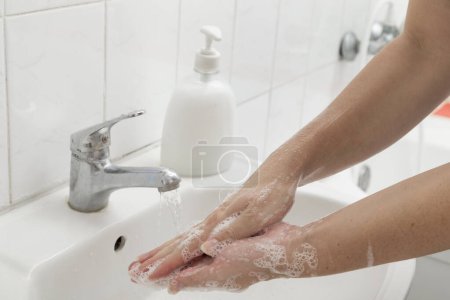 Téléchargez les photos : Gros plan d'une femme se lavant les mains. Focus sélectif sur la main - en image libre de droit