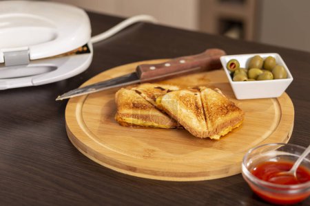Photo for Detail of hot sandwiches on a wooden cutting board ready for eating. Selective focus on the sandwiches - Royalty Free Image