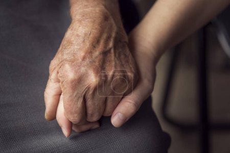 Photo for Close up of an old, wrinkled and young hand with smooth skin, one in another. Elderly care and respect, selective focus - Royalty Free Image