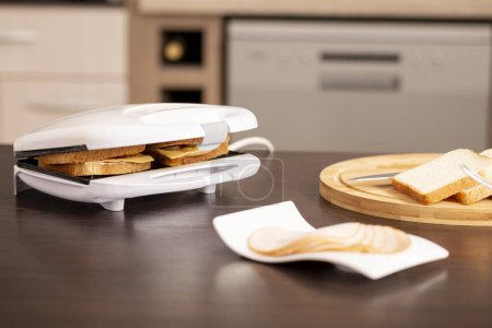 Foto de Detalle de sándwiches calientes que se preparan en una sandwichera. Enfoque selectivo en los sándwiches - Imagen libre de derechos