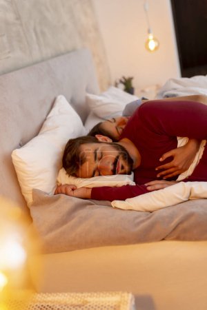 Téléchargez les photos : Beau jeune couple amoureux en pyjama couché étreint dans le lit, cuillère pendant le sommeil - en image libre de droit