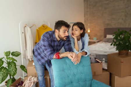 Photo for Couple in love moving in together, taking a break from unpacking the boxes and planning the arrangement and decoration of the apartment - Royalty Free Image