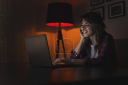 Foto de Hermosa joven disfrutando de su tiempo libre, navegando por la red en su computadora portátil - Imagen libre de derechos