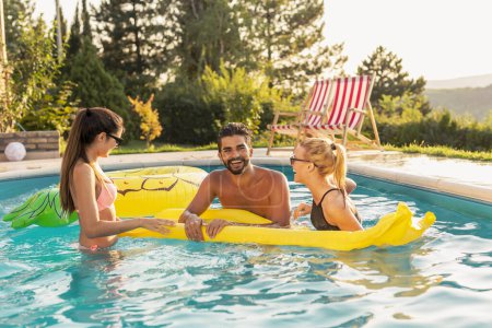Gruppe von Freunden auf einer Sommerparty am Pool, Spaß im Schwimmbad, Sonnenbaden auf einer schwimmenden Matratze