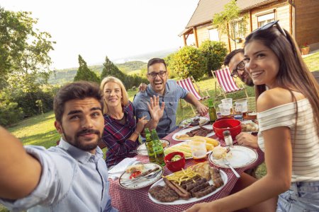 Photo for Group of friends having a backyard barbecue party, having fun taking selfies - Royalty Free Image