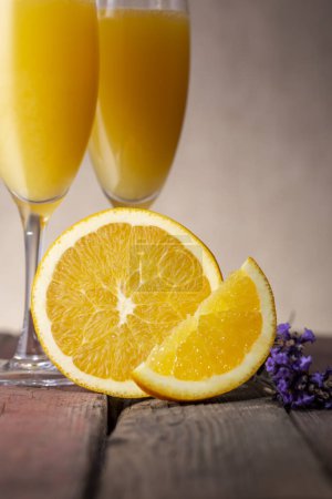 Téléchargez les photos : Cocktails Mimosa dans des verres à champagne au jus d'orange et vin mousseux décoré de feuilles de lavande et de tranches d'orange - en image libre de droit