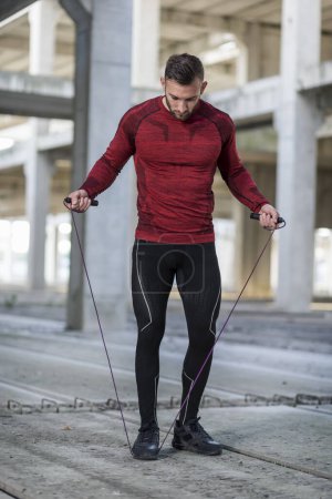 Foto de Atlético, hombre musculoso haciendo un ejercicio cardiovascular de cuerda de salto - Imagen libre de derechos