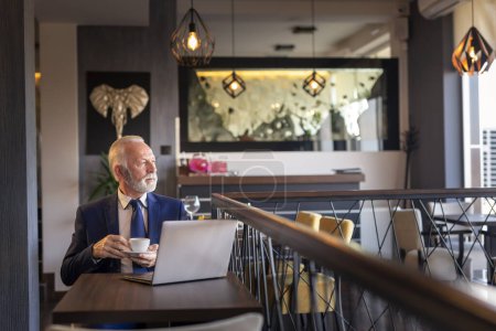 Photo for Senior businessman on a coffee break in restaurant, sitting at a restaurant table, having a cup of coffee - Royalty Free Image