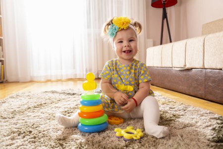 Foto de Hermosa niña jugando con pilas de colores de diferentes círculos de tamaño juguete didáctico - Imagen libre de derechos