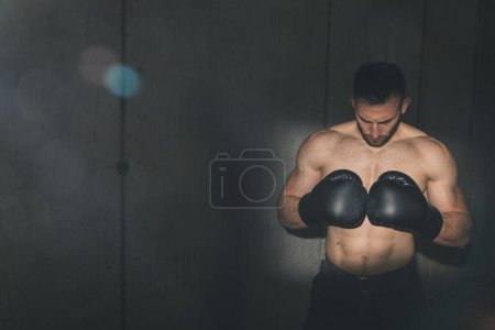 Téléchargez les photos : Convient boxeur musclé portant des gants de boxe, se préparant pour un match de boxe - en image libre de droit