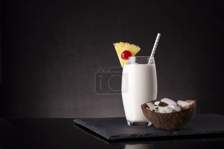 Foto de Copa de cóctel de piña colada con ron oscuro, jugo de piña y crema de coco, decorado con rodajas de piña y cereza al maraschino - Imagen libre de derechos