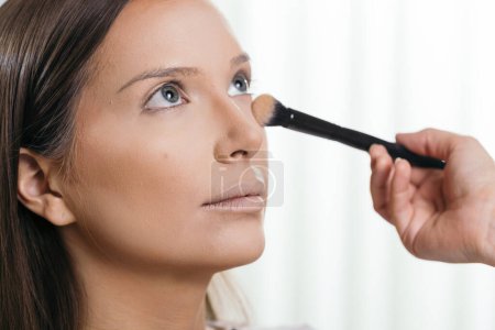 Foto de Maquillaje artista haciendo maquillaje de la modelo, la aplicación de la cara en polvo con un cepillo de maquillaje - Imagen libre de derechos