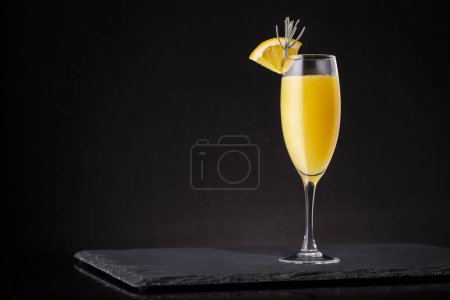 Téléchargez les photos : Cocktail Mimosa dans un verre de champagne au jus d'orange et vin mousseux décoré de feuilles de lavande et de tranches d'orange - en image libre de droit