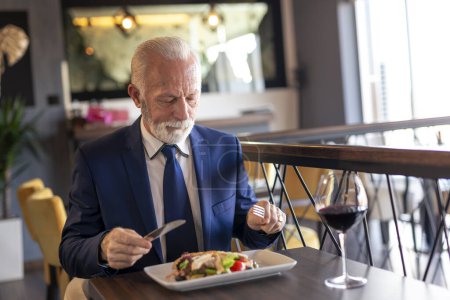Téléchargez les photos : Homme d'affaires senior faisant une pause, en pause déjeuner au restaurant - en image libre de droit