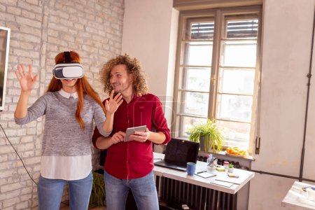 Téléchargez les photos : Des collègues d'affaires s'amusent à utiliser des lunettes VR au bureau ; des gens d'affaires testent le heaadset de réalité virtuelle sur le lieu de travail - en image libre de droit