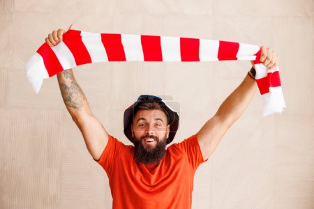 Foto de Retrato de un fanático del fútbol masculino celebrando una bufanda animando a su equipo anotando un gol en el partido del campeonato mundial - Imagen libre de derechos