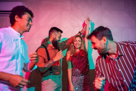 Téléchargez les photos : Groupe de jeunes amis joyeux qui s'amusent à chanter et danser lors d'une fête - en image libre de droit