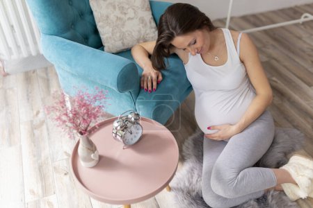 Photo for High angle view of a beautiful young nine months pregnant woman relaxing at home, expecting her baby - Royalty Free Image