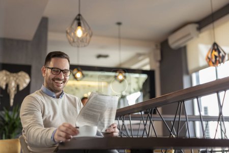 Foto de Hombre sentado en una mesa de restaurante, leyendo el periódico y tomando café - Imagen libre de derechos