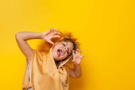 Photo for Child dressed in lion carnival costume roaring, isolated on yellow colored background with copy space - Royalty Free Image
