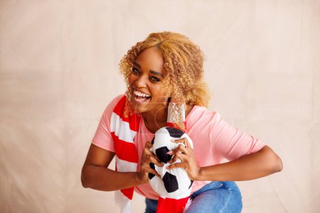 Téléchargez les photos : Fan de football féminin tenant un ballon de football acclamant pour son équipe nationale au championnat du monde - en image libre de droit