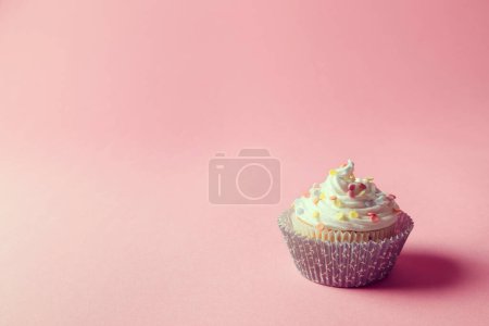 Photo for One nicely decorated cupcake with cream and sprinkles on it, isolated on pink background - Royalty Free Image