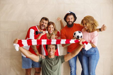 Téléchargez les photos : Groupe de fans de football joyeux en maillots de sport avec des accessoires encourageants se préparer pour le match de championnat du monde - en image libre de droit