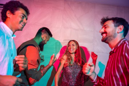 Téléchargez les photos : Groupe joyeux d'amis qui s'amusent à chanter et danser lors d'une fête - en image libre de droit