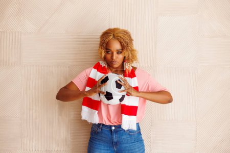 Téléchargez les photos : Fan de football féminin tenant un ballon de football acclamant pour son équipe nationale au championnat du monde - en image libre de droit