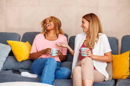 Foto de Dos mujeres se divierten pasando tiempo libre juntas en casa, bebiendo café y leyendo símbolos de la taza después, diciendo fortuna - Imagen libre de derechos