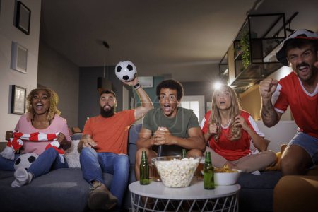 Téléchargez les photos : Groupe de personnes applaudir et regarder le match de football à la télévision, célébrer la victoire après que leur équipe a marqué un but - en image libre de droit