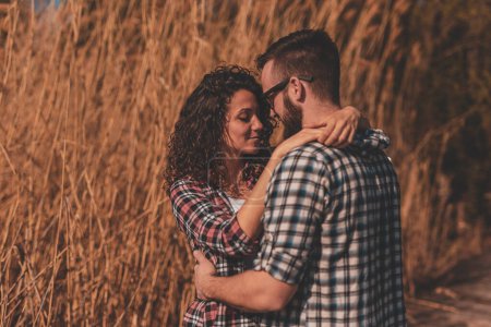 Téléchargez les photos : Beau jeune couple amoureux s'amuser en plein air, passer une journée ensoleillée dans la nature, embrasser et embrasser sur les quais du lac - en image libre de droit