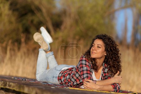Photo for Woman lying on the lake docks, relaxing after a long day of hiking, enjoying beautiful day in nature - Royalty Free Image