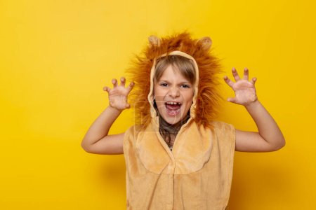 Photo for Beautiful little girl wearing lion carnival costume roaring, isolated on yellow colored background - Royalty Free Image