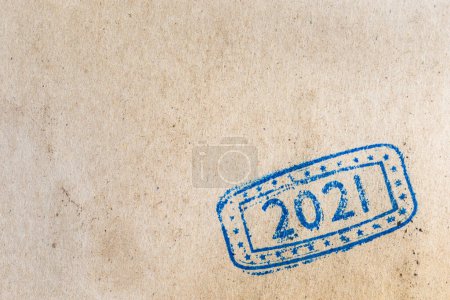 Foto de Hoja de estampado de tinta de papel marrón rústico; primer plano del sello de tinta con números 2021 que representa el próximo Año Nuevo en la página de papel marrón rústico con espacio de copia - Imagen libre de derechos