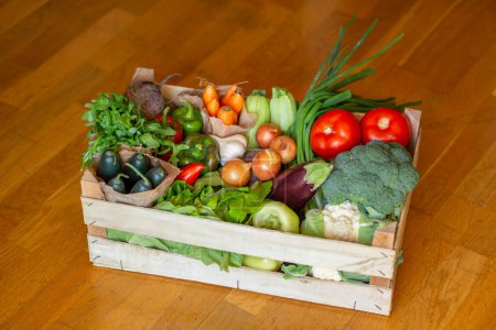 Foto de Caja de madera llena de varias verduras orgánicas frescas acaba de entregar a la dirección del hogar - Imagen libre de derechos