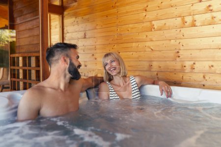 Foto de Hermosa pareja joven enamorada relajándose en un hotel resort spa centro bañera de hidromasaje mientras está de vacaciones - Imagen libre de derechos