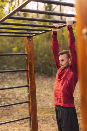 Photo for Men in sportswear stretching out after an outdoor workout session in a street workout park - Royalty Free Image