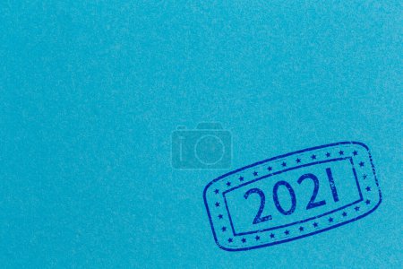 Téléchargez les photos : Feuille de timbre d'encre de papier bleu ; gros plan du timbre d'encre avec les numéros 2021 représentant le Nouvel An à venir sur la page de papier bleu avec espace de copie - en image libre de droit