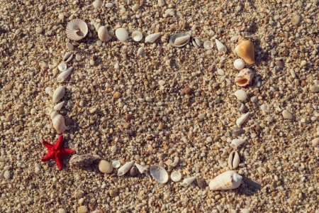 Téléchargez les photos : Cadre photo en coquillages et galets sur la plage - en image libre de droit