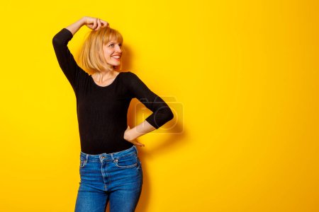 Téléchargez les photos : Portrait de belle jeune femme gaie pensant isolé sur fond de couleur jaune avec espace de copie - en image libre de droit
