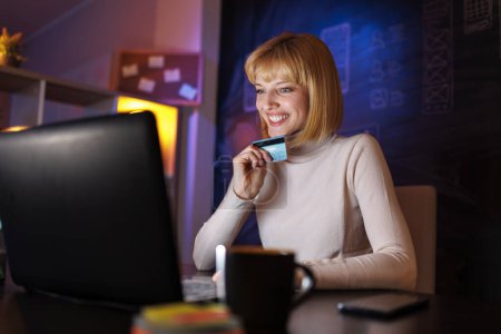 Foto de Mujer usando ordenador portátil de compras en línea insertar el número de tarjeta de crédito, mientras que los pagos - Imagen libre de derechos