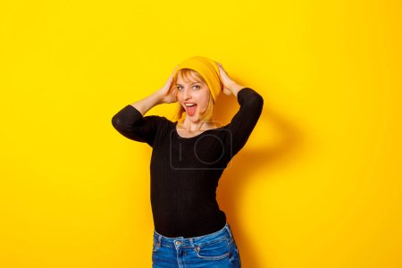 Téléchargez les photos : Portrait d'heureuse belle jeune femme blonde souriante isolée sur fond de couleur jaune - en image libre de droit