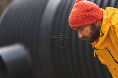 Téléchargez les photos : Homme athlétique se détendre et faire une pause tout en faisant du jogging à l'extérieur par une journée d'hiver nuageuse - en image libre de droit