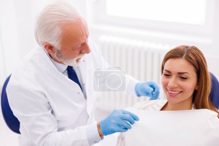 Foto de Mujer en el consultorio del dentista sentada en la silla dental lista para chequear - Imagen libre de derechos