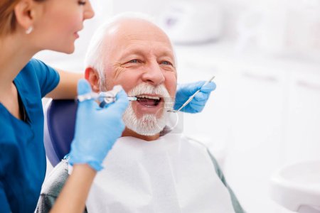 Zahnärztin verabreicht Lokalanästhesie an Patientin zur Betäubung der Schmerzen vor dem Eingriff