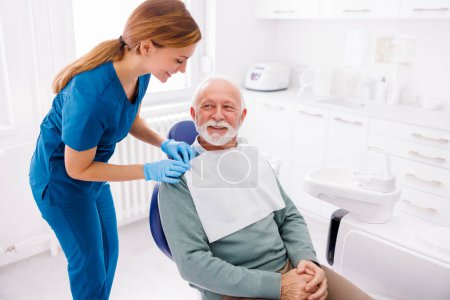 Foto de Hombre mayor en la oficina del dentista sentado en la silla dental listo para el chequeo - Imagen libre de derechos
