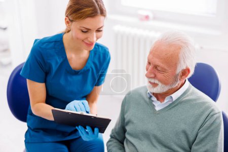 Photo for Senior man having dental checkup at dentist office, consulting with doctor about necessary procedures - Royalty Free Image